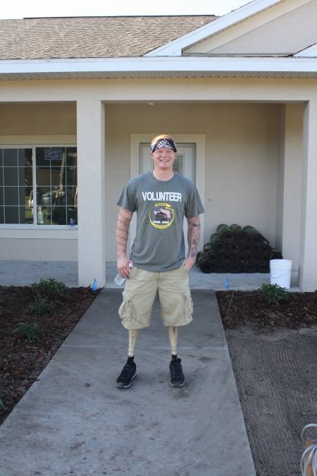 Corporal Justin Gaertner in front of the home he will receive in December during a recent volunteer work day. 